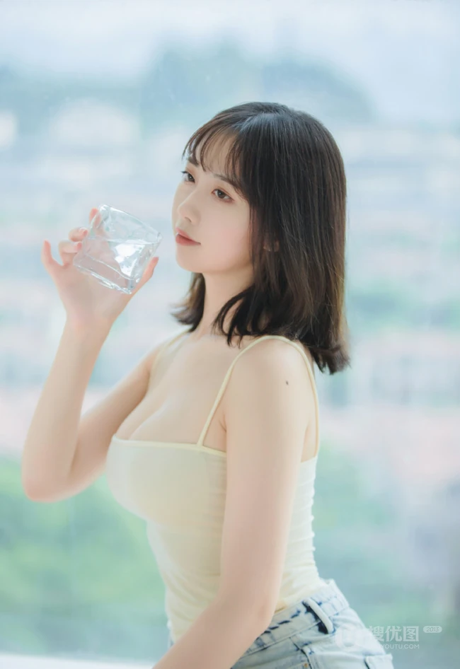 气质匀称温柔型圆脸女生，肩带衣搭牛仔热裤居家悠闲写真吸睛美照
