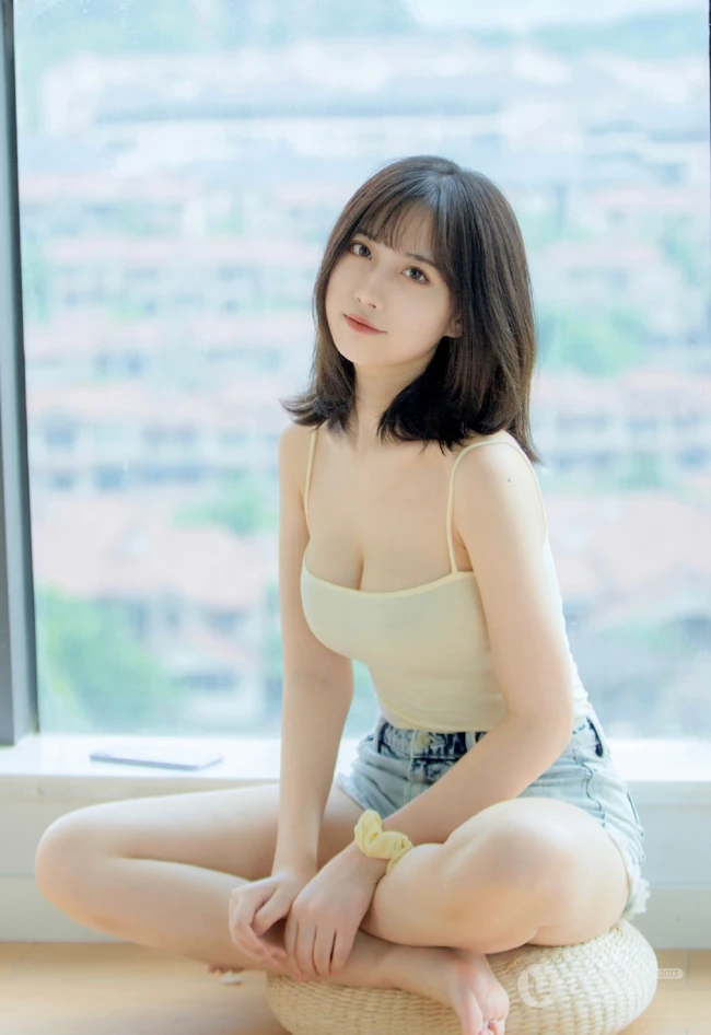 气质匀称温柔型圆脸女生，肩带衣搭牛仔热裤居家悠闲写真吸睛美照