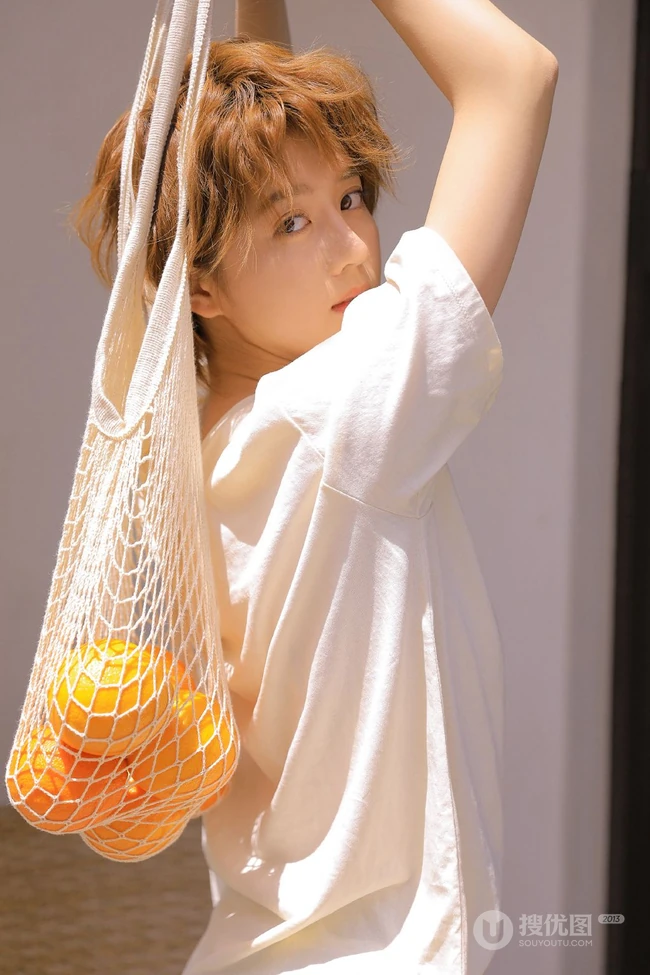 李凯馨手拿橙子清新夏日短裤写真，最新款金色短发更显清爽靓丽
