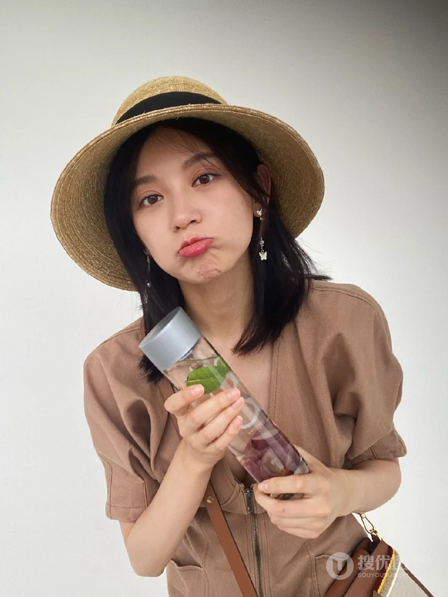 施诗外出游玩心情好，头戴草帽，身穿V领拉链连衣短裙，气质大方
