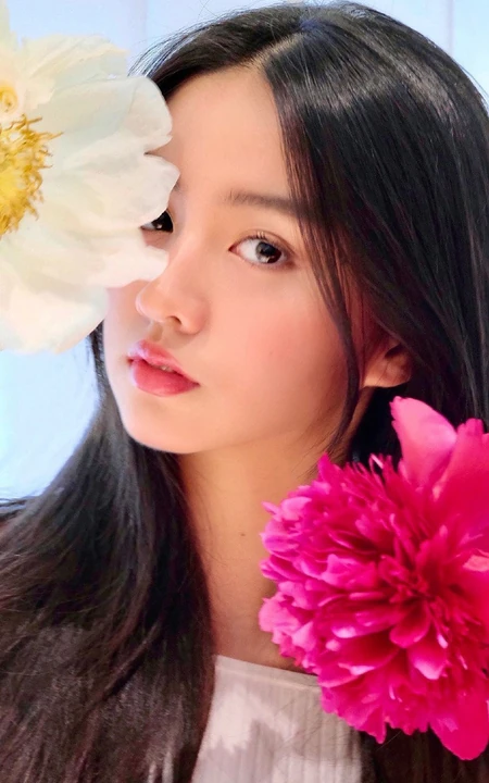 木村光希与花合影半遮娇颜，长发柔顺，难掩落落大方少女气质