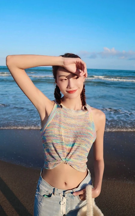 李斯羽针织小背心搭配牛仔长裤，大秀纤细线条海边写真美照