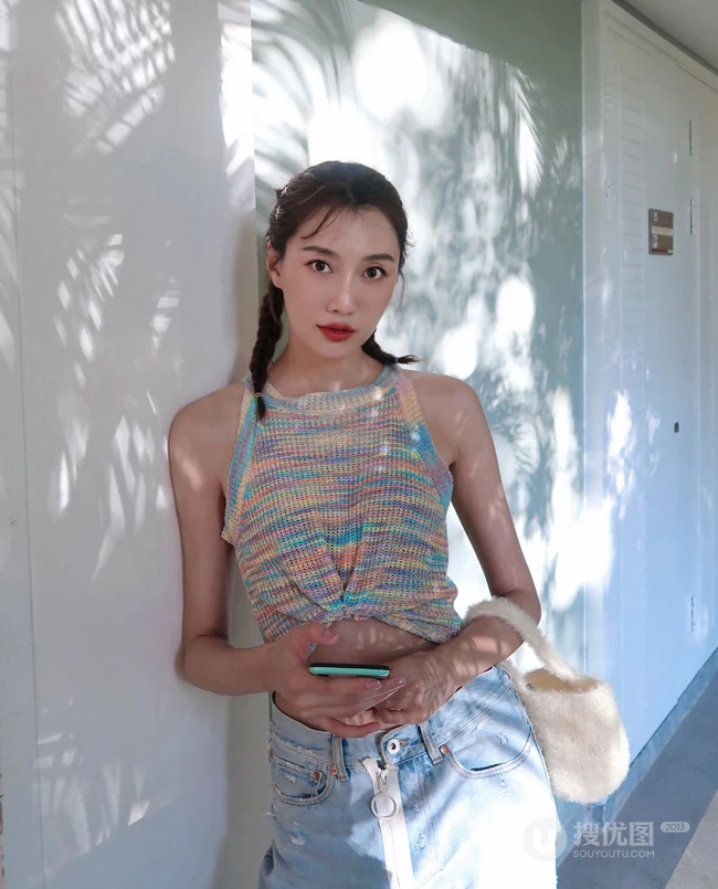 李斯羽针织小背心搭配牛仔长裤，大秀纤细线条海边写真美照