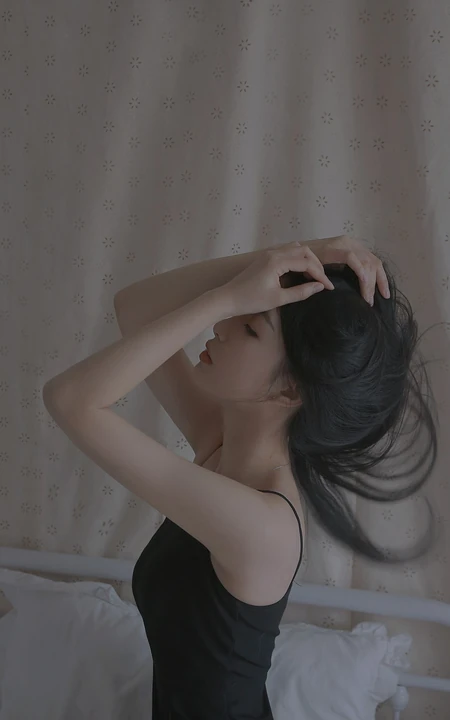 黑色背心美女，侧脸，坐在床上，双手撩发的性感女人2K手机壁纸