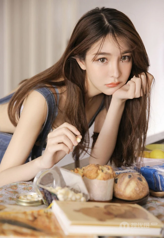 肤白貌美长发靓丽背带牛仔裤少女与零食为伴气质清新居家写真照
