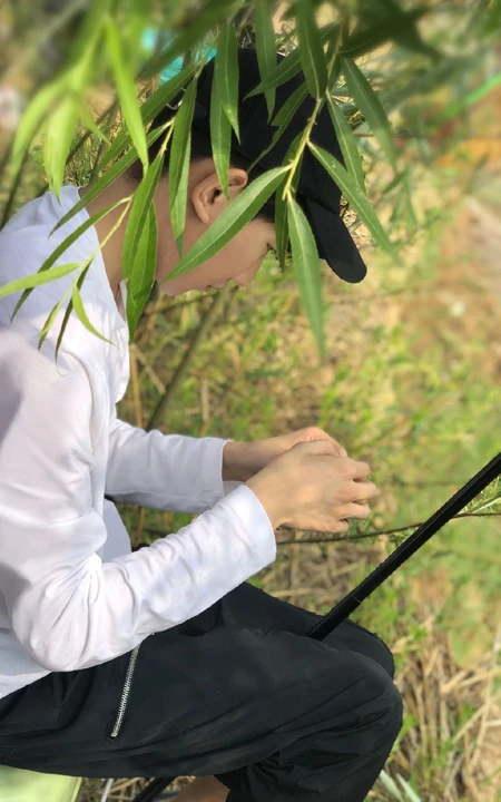 王源休闲装扮户外认真钓鱼图片
