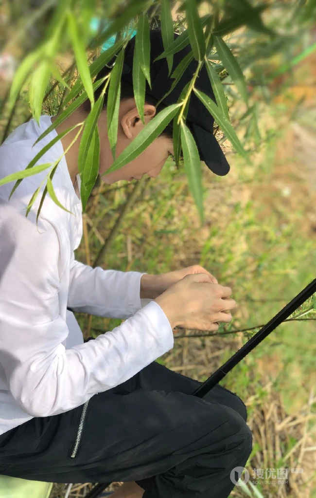 王源休闲装扮户外认真钓鱼图片