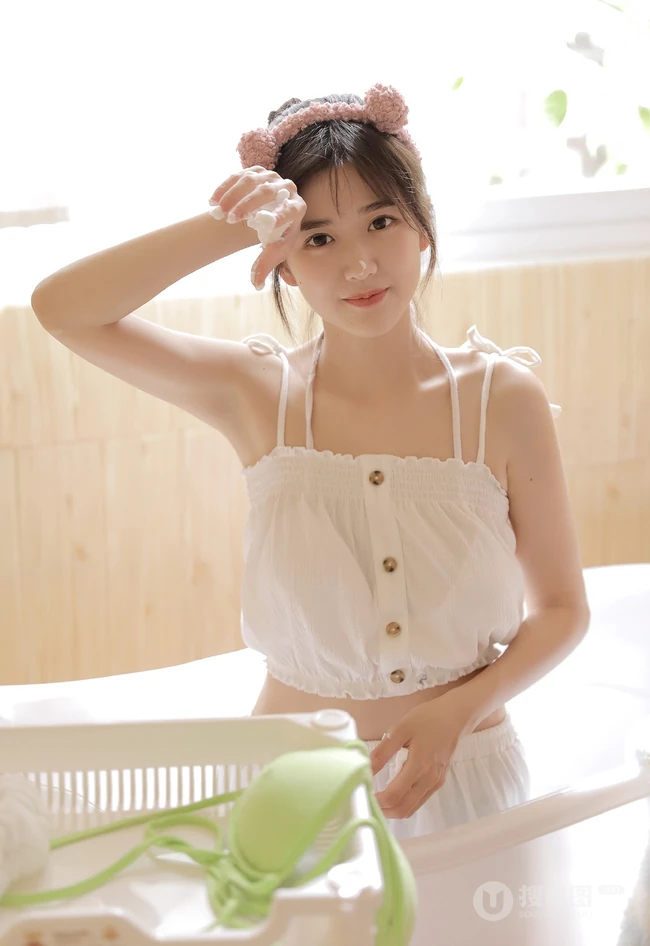 可爱型圆脸少女纯白肩带衣短裤在浴缸里玩耍写真图片