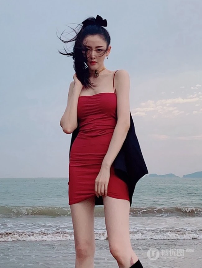 张天爱一袭紧身肩带红裙现身海边沙滩气质生活照片