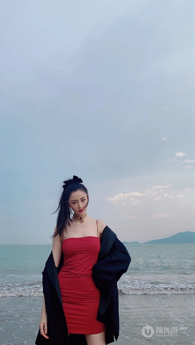 张天爱一袭紧身肩带红裙现身海边沙滩气质生活照片