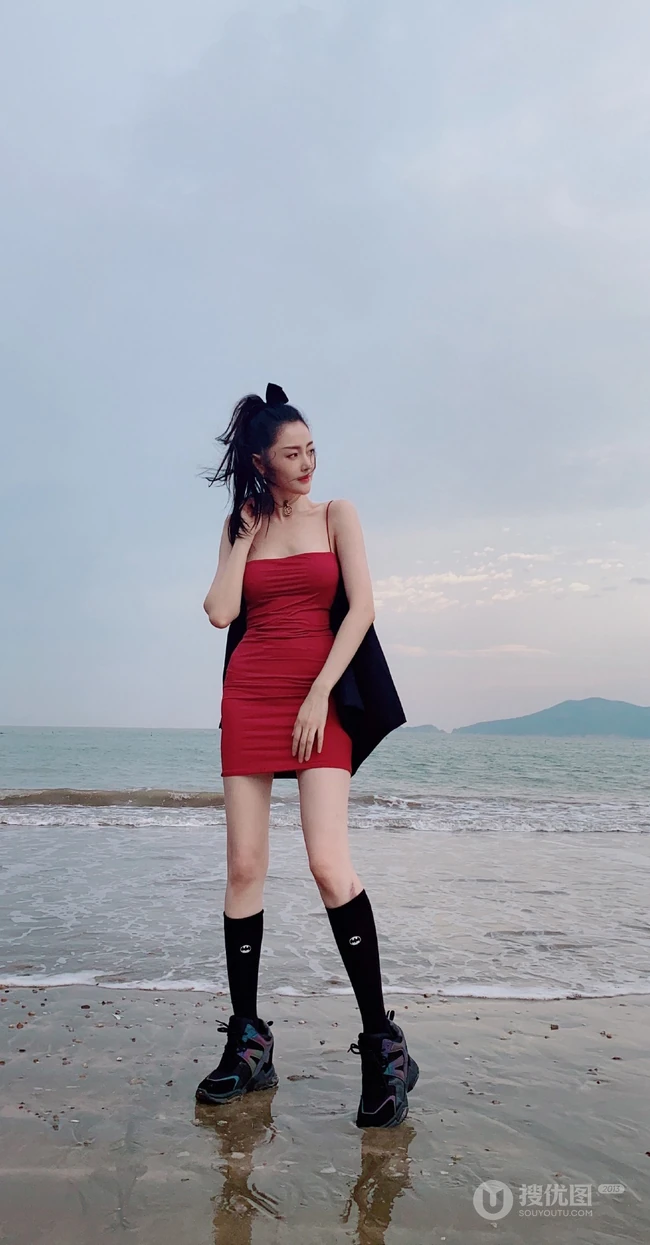 张天爱一袭紧身肩带红裙现身海边沙滩气质生活照片