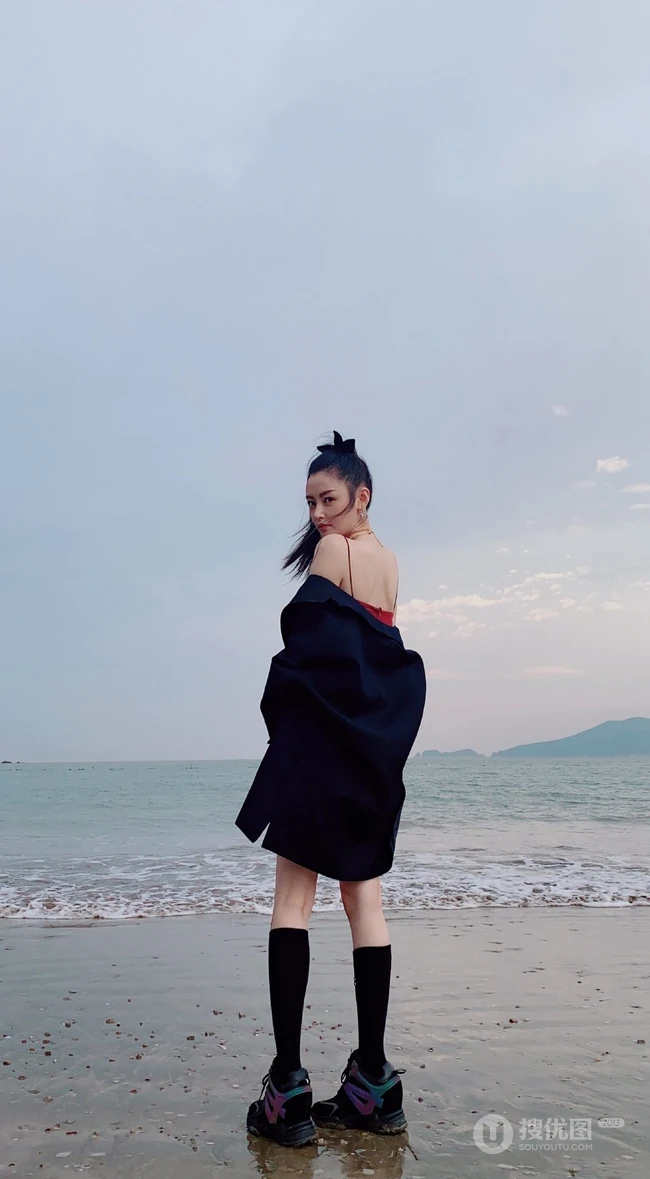 张天爱一袭紧身肩带红裙现身海边沙滩气质生活照片