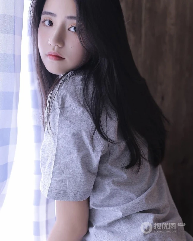 抱膝而坐，恬静温柔，长发T恤衫短裤文静型女孩居家写真图片