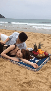这是在拍什么？侧躺在海边沙滩上出一堆男女亲密gif图片