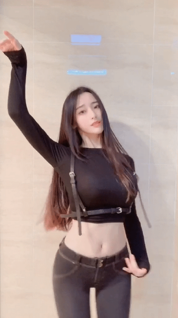 镜头前，穿着紧身黑衣牛仔裤的长发女生扭屁股动态图片