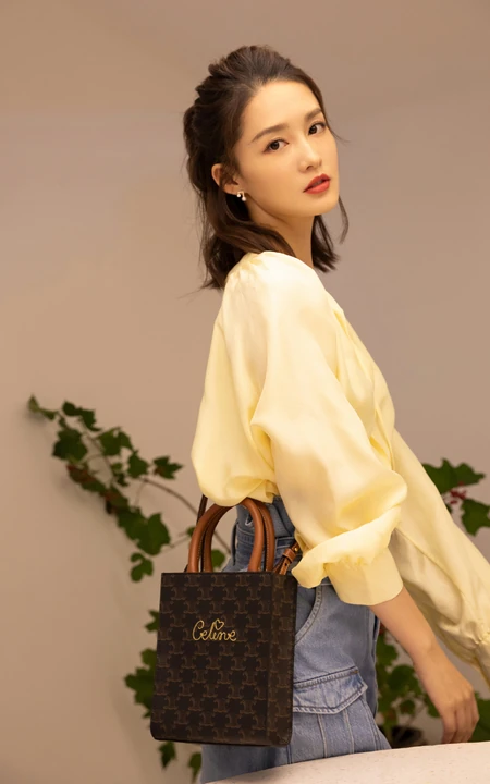李沁身着淡黄色纯色衬衣，高腰牛仔裤搭配时尚穿搭美照