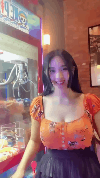 抓娃娃机前的匀称低领装匀称女生GIF动态图片