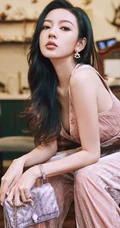 何瑞贤化身气质粉装伊人，身材苗条，长发柔顺，手拿包包优雅大方