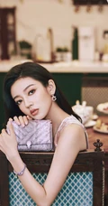 何瑞贤化身气质粉装伊人，身材苗条，长发柔顺，手拿包包优雅大方