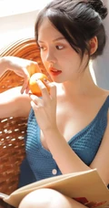 气质清纯低领装短裤少女居家看杂志，吃水果悠闲曝光写真图片