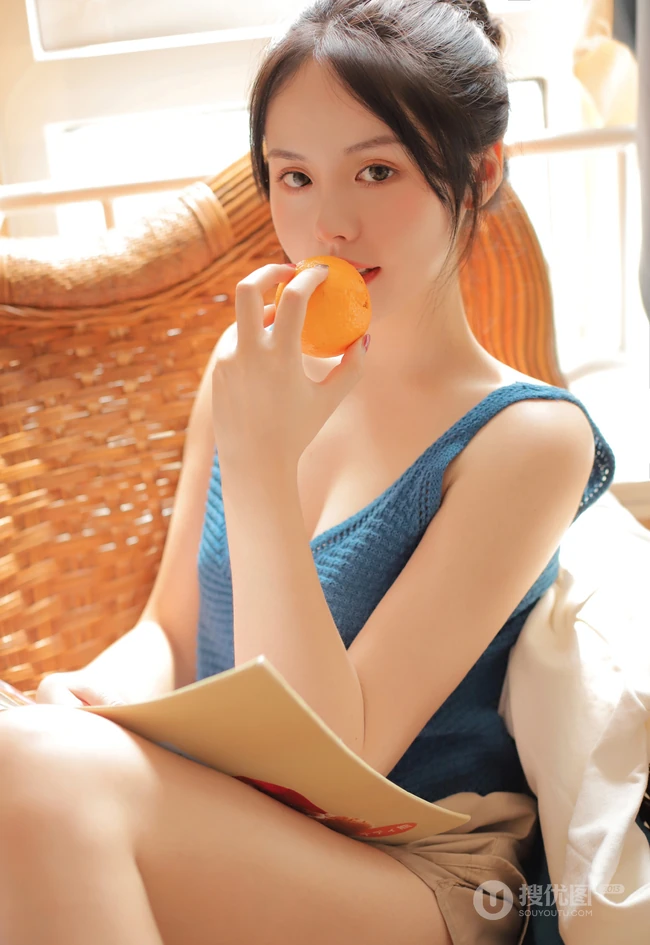 气质清纯低领装短裤少女居家看杂志，吃水果悠闲曝光写真图片