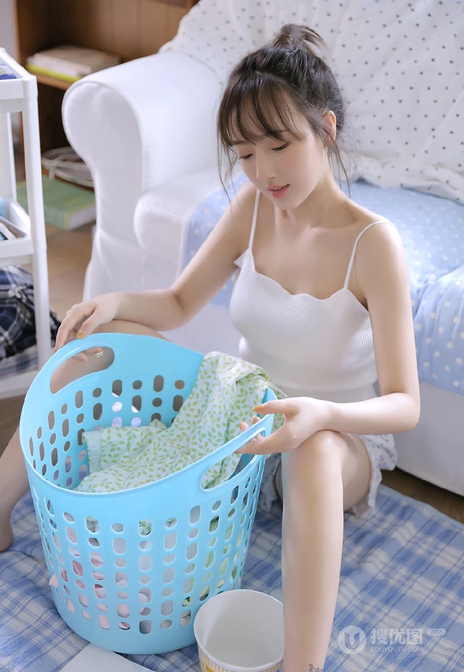 浅粉白皙双眼皮少女肩带背心短裤居家整理衣物，剪指甲写真图片