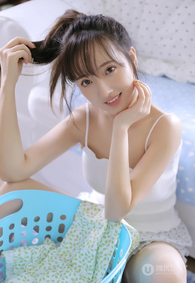 浅粉白皙双眼皮少女肩带背心短裤居家整理衣物，剪指甲写真图片