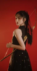 背弓箭的少女，红色背景前的背箭长发少女飒美摄影艺术写真照