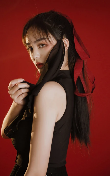 背弓箭的少女，红色背景前的背箭长发少女飒美摄影艺术写真照