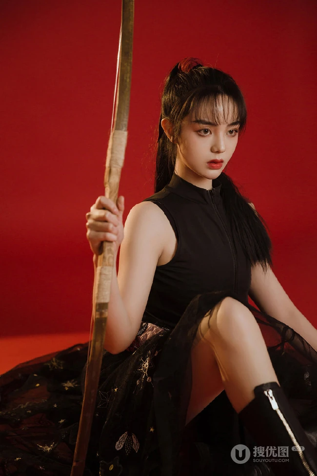 背弓箭的少女，红色背景前的背箭长发少女飒美摄影艺术写真照