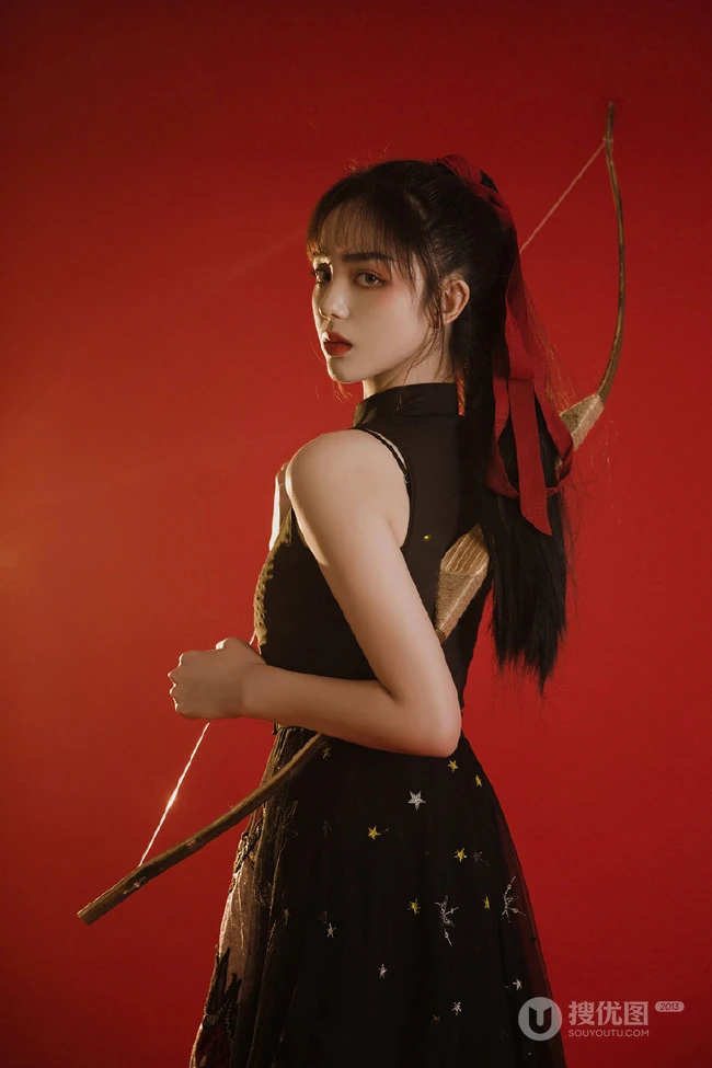 背弓箭的少女，红色背景前的背箭长发少女飒美摄影艺术写真照