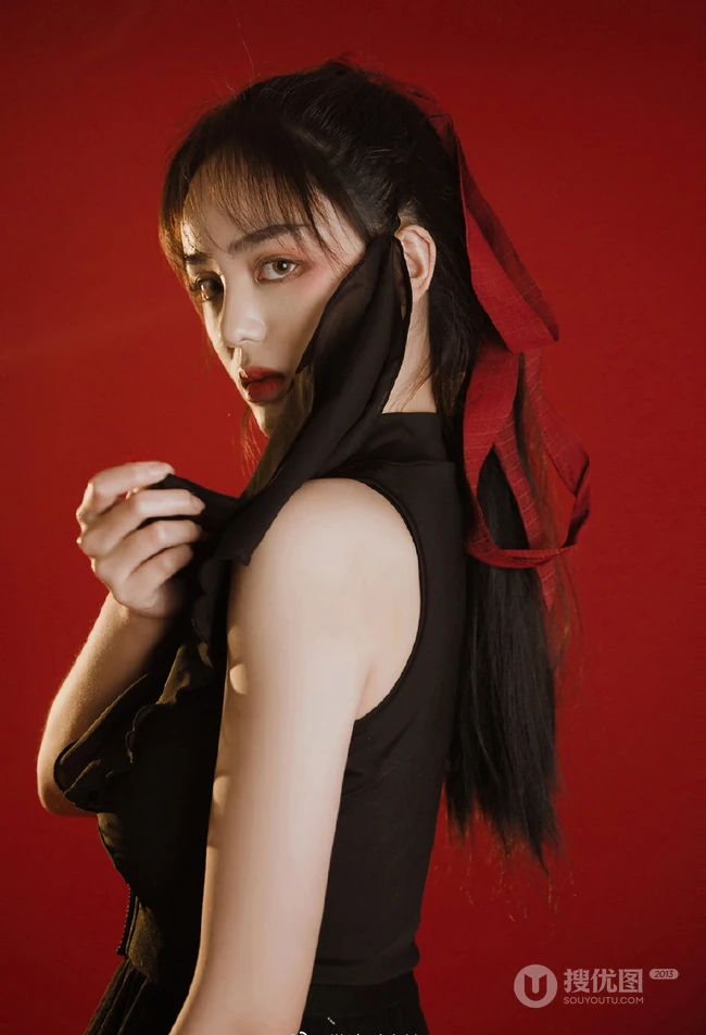 背弓箭的少女，红色背景前的背箭长发少女飒美摄影艺术写真照