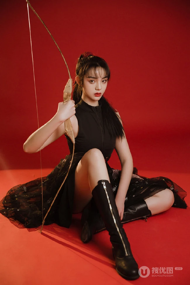 背弓箭的少女，红色背景前的背箭长发少女飒美摄影艺术写真照