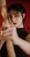 背弓箭的少女，红色背景前的背箭长发少女飒美摄影艺术写真照