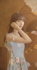 手拿郁金香的漂亮长发少女，身穿印花肩带裙在朦胧感的室内中举止动人