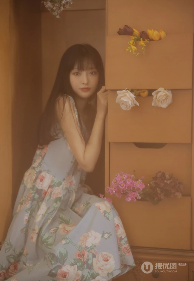手拿郁金香的漂亮长发少女，身穿印花肩带裙在朦胧感的室内中举止动人