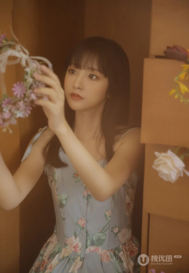 手拿郁金香的漂亮长发少女，身穿印花肩带裙在朦胧感的室内中举止动人