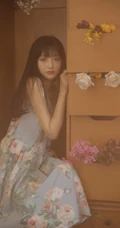 手拿郁金香的漂亮长发少女，身穿印花肩带裙在朦胧感的室内中举止动人