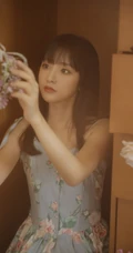 手拿郁金香的漂亮长发少女，身穿印花肩带裙在朦胧感的室内中举止动人