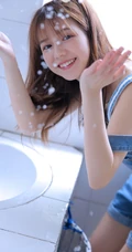 美丽可爱的苗条女孩，穿着背带牛仔裤洗衣房蹲着玩水龙头俏皮写真美照