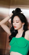 王霏霏化身电梯女郎，绿色肩带礼裙装搭配黑色皮裙，动人动作气质柔美