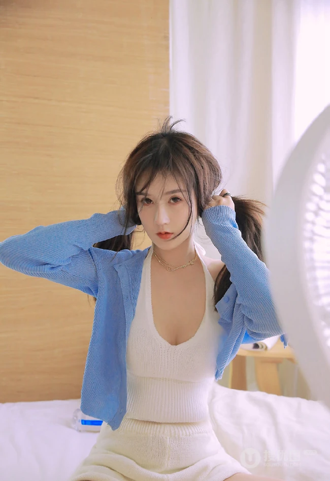 坐在室内的白皙气质女生气质写真，白色肩带低领衣套装短裤和妹子很搭哦!