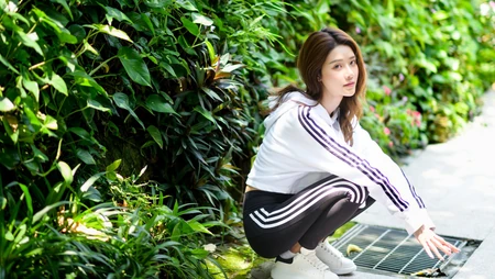 蹲在马路边的长发运动装美女高清电脑壁纸
