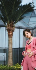 万茜身着粉色西服礼裙衣酷飒写真，大厦前的绿色草地上休庭信步