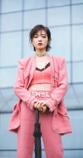 万茜身着粉色西服礼裙衣酷飒写真，大厦前的绿色草地上休庭信步