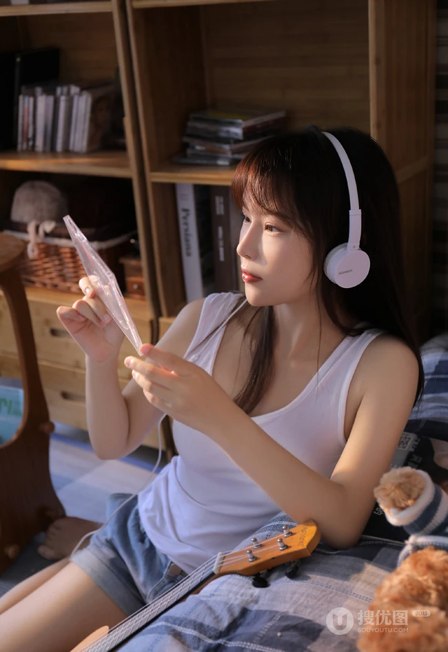 不穿家居服的简约白背心牛仔短裤少女怡然自得居家写真图片