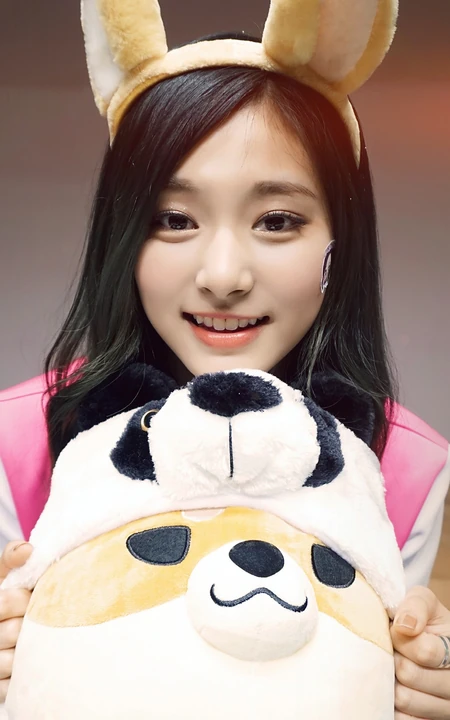 抱熊猫公仔戴着兔耳朵头套的可爱亚洲美女