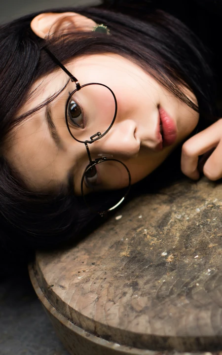戴圆形眼镜趴在切菜板上的清纯美女