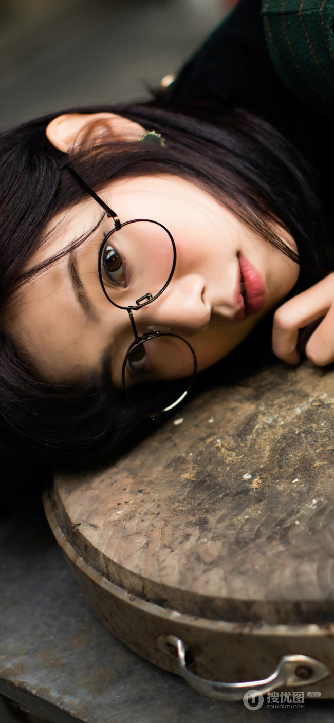 戴圆形眼镜趴在切菜板上的清纯美女