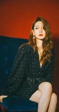 戚薇时尚柔美卷发发型，搭配黑衣波点裙，静坐沙发写真照